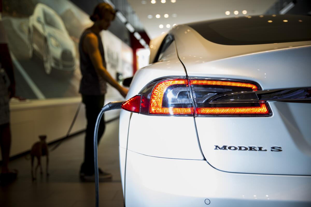 A Tesla Model S is plugged in inside the Third Street Promenade Tesla showroom in Santa Monica.