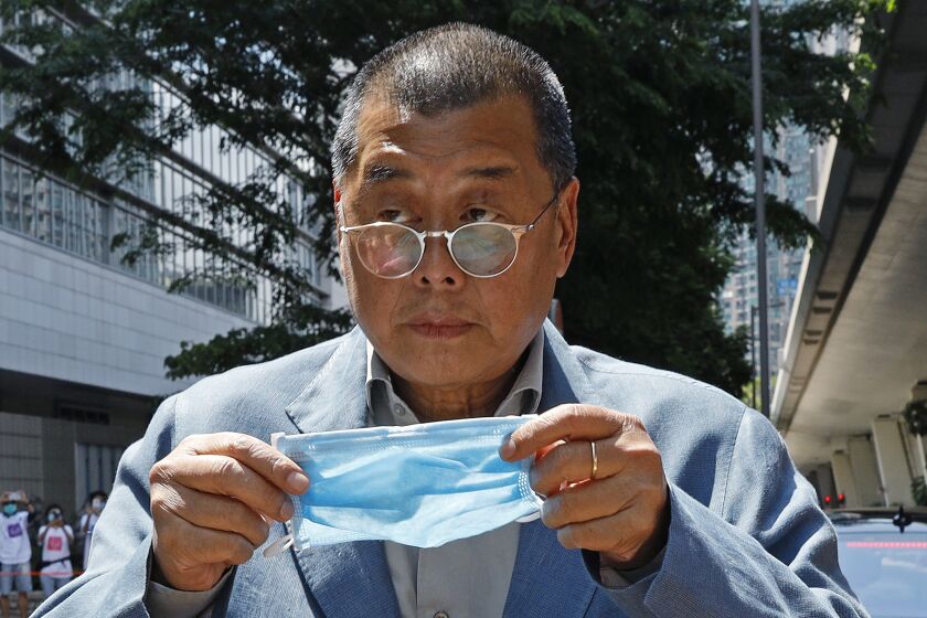 FILE - Hong Kong media tycoon Jimmy Lai, who founded local newspaper Apple Daily, is about to wear a face mask before entering a court in Hong Kong on May 5, 2020. A Hong Kong court on Friday, May 19, 2023 dismissed the jailed pro-democracy publisher's legal bid in his fight to use a British lawyer in his landmark national security trial. (AP Photo/Kin Cheung, File)
