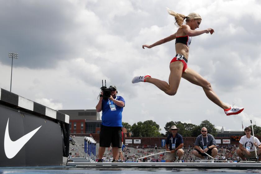 FILE - Emma Coburn leaps over the water pit during the women's 3,000-meter steeplechase at the U.S. Championships athletics meet, on June 23, 2018, in Des Moines, Iowa. Three-time U.S. Olympian Emma Coburn says her “dream of Paris is over” after breaking her ankle at the Diamond League meet in Shanghai and undergoing surgery. (AP Photo/Charlie Neibergall, File)