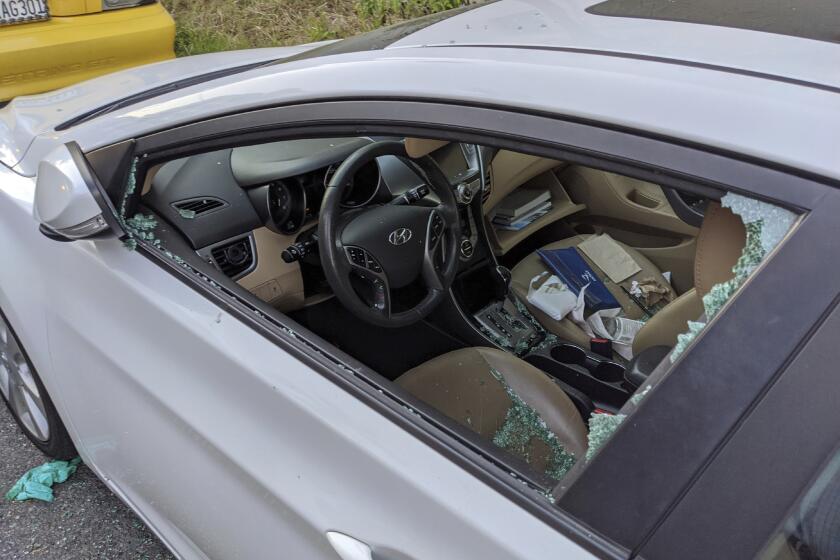 This Thursday, May 21, 2020, photo shows a parked car with a broken driver's side window after a smash-and-grab break-in in Los Angeles. The coronavirus hasn't been kind to car owners. With more people than ever staying home to lessen the spread of COVID-19, their sedans, pickup trucks and SUVs are parked unattended on the streets, making them easy targets for opportunistic thieves. (AP Photo/Damian Dovarganes)