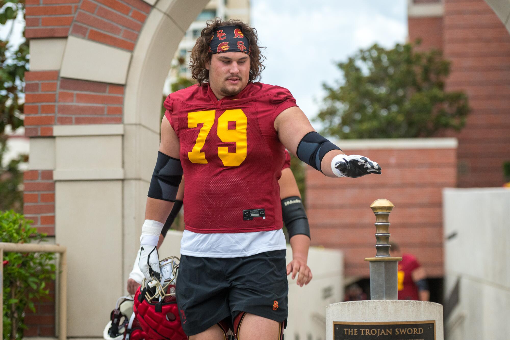 USC offensive lineman Jonah Monheim taps a sword before football practice. 