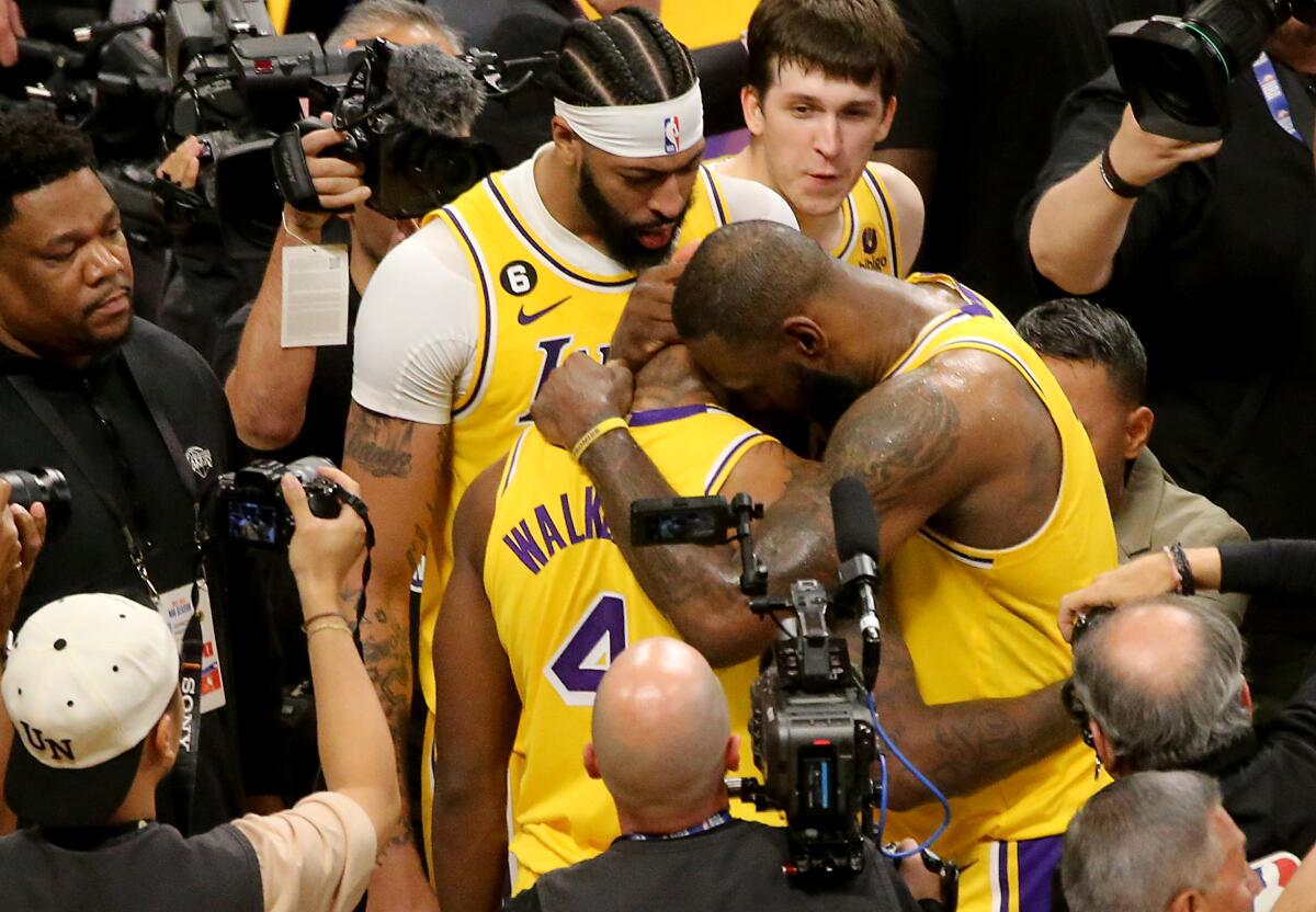 Lonnie Walker IV gets a hug from LeBron James after the Lakers beat the Warriors on Monday.