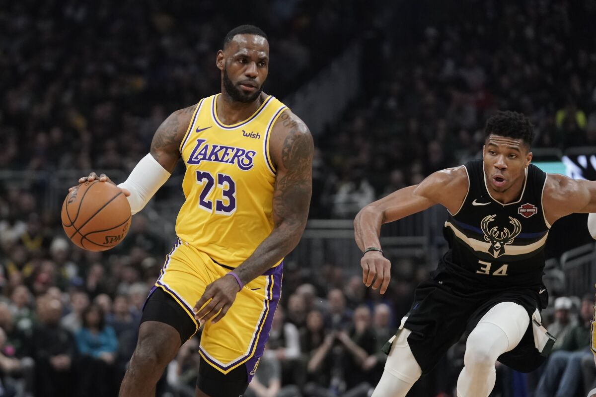 The Lakers' LeBron James dribbles past the Bucks' Giannis Antetokounmpo on Thursday in Milwaukee.