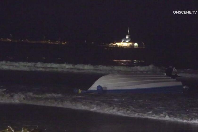A suspected smuggling boat capsized Monday night off Imperial Beach north of the Imperial Beach Pier, seen here in the background.
