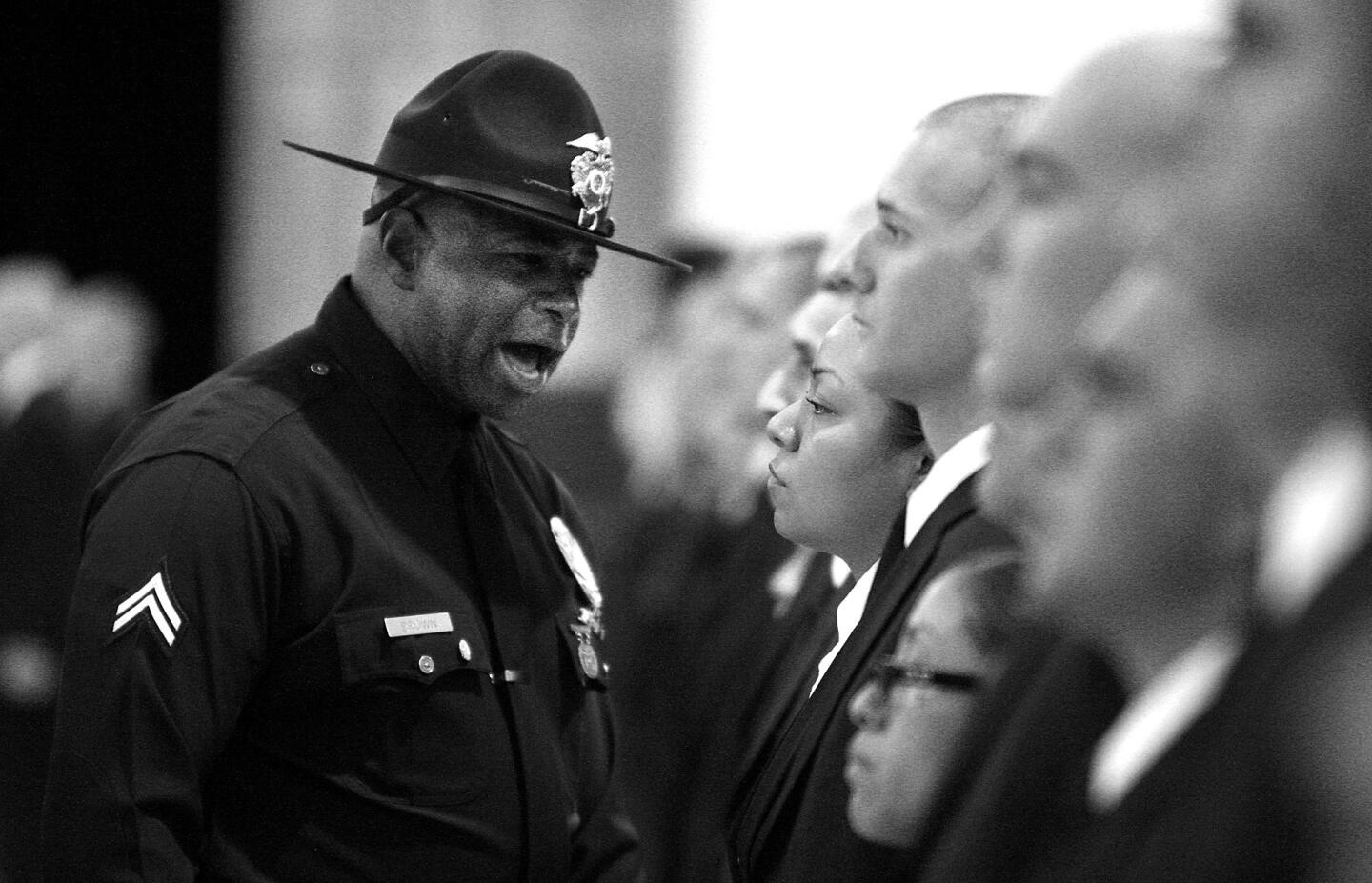 A training officer, left, screams at recruits on their first day at the Police Academy.
