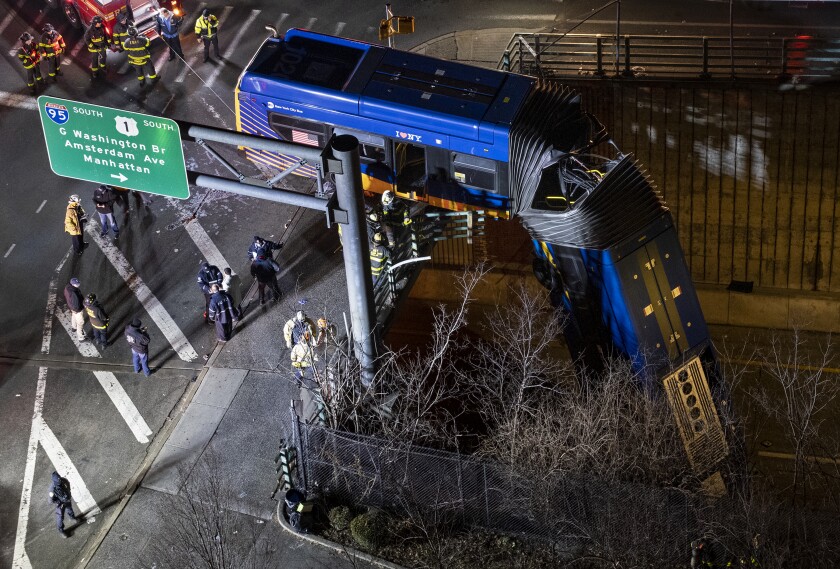 A bus in New York City which careened off a road in the Bronx neighborhood of New York is left dangling from an overpass Friday, Jan. 15, 2021, after a crash late Thursday that left the driver in serious condition, police said. (AP Photo/Craig Ruttle)