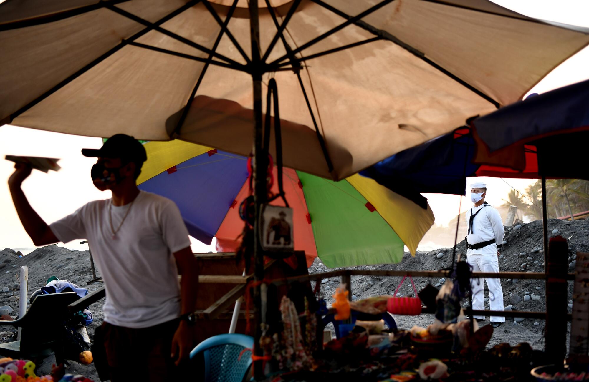 Vendors wait for customers as Salvadoran sailors serves as security. 