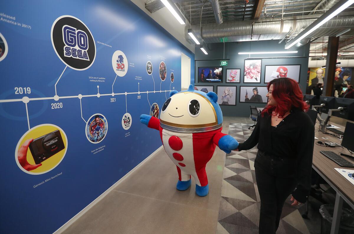A Sega mascot walks the timeline of the development history wall at Sega of America's North American headquarters in Irvine.