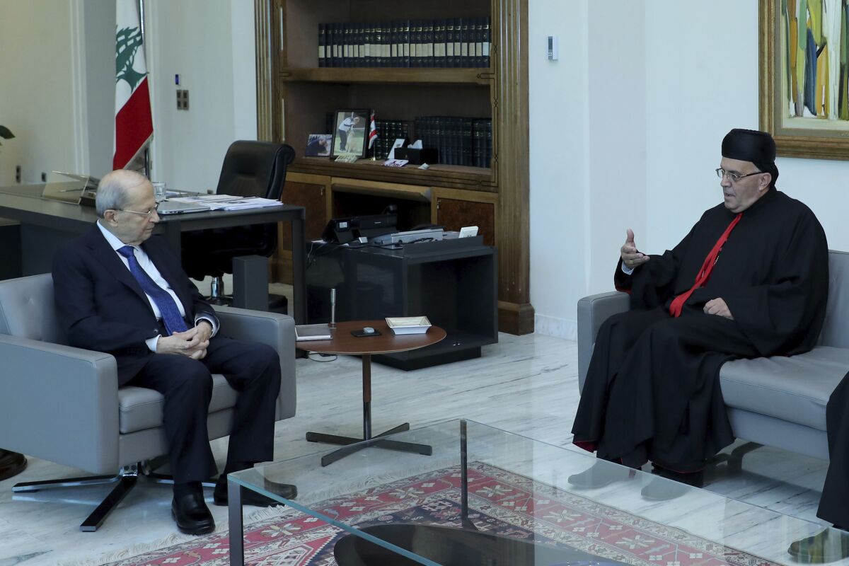 In this photo released by Lebanon's official government photographer Dalati Nohra, Lebanese president Michel Aoun meets with Lebanese Maronite archbishop Moussa el-Hajj, at the presidential palace, in Baabda east of Beirut, Lebanon, July 22, 2022. The brief detention of el-Hajj who was caught with more than $450,000 in cash as he crossed from Israel to Lebanon is further stoking sectarian tensions in his crisis-hit homeland. (Dalati Nohra via AP)