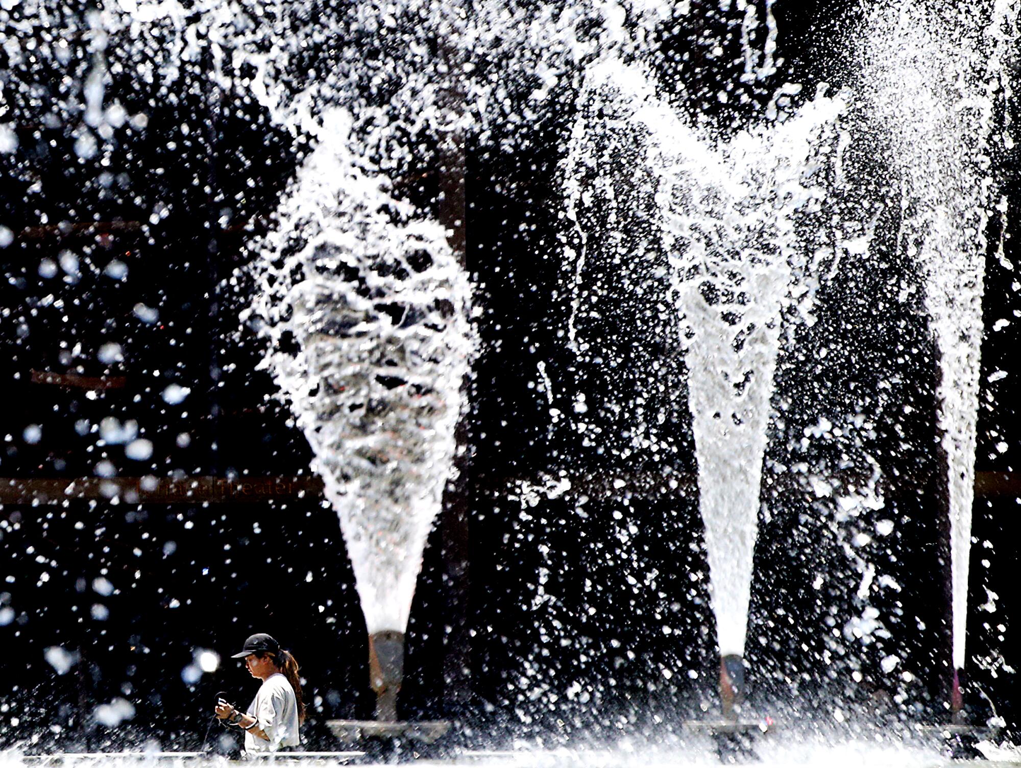 Splashing water fountains mist the area around the Long Beach Performing Arts Center Plaza.