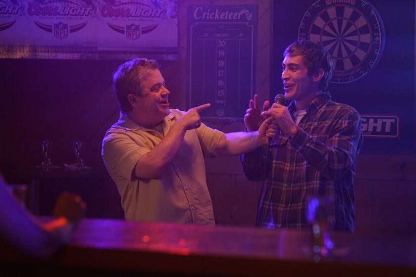 Two men play with a microphone in a bar in the movie "I Love My Dad."