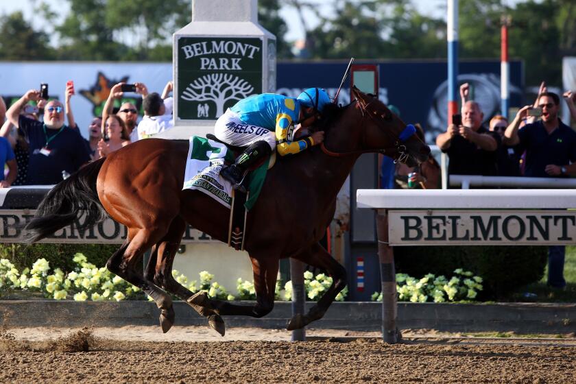 Jockey Victor Espinoza guides American Pharoah across the finish line to win the 147th Belmont Stakes on Saturday in Elmont, N.Y.