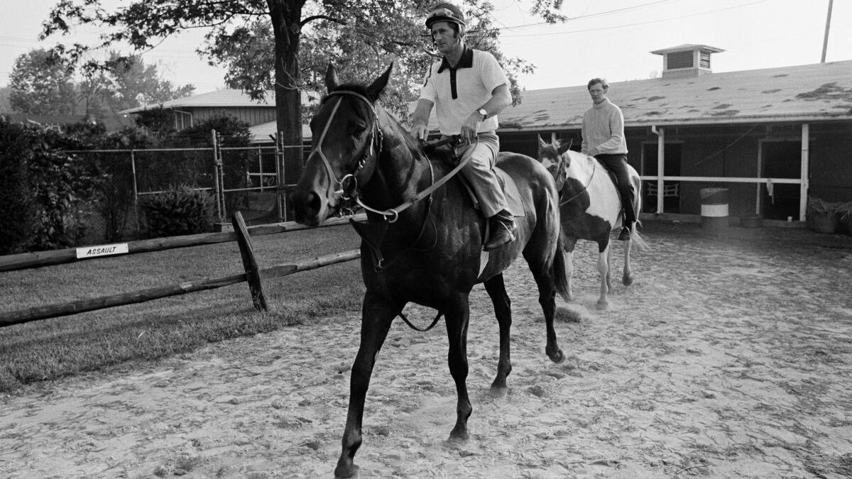 Seattle Slew, with exercise boy Mike Kennedy, returns to his Pimlico barn on May 20, 1977, after his final workout before the Preakness Stakes.