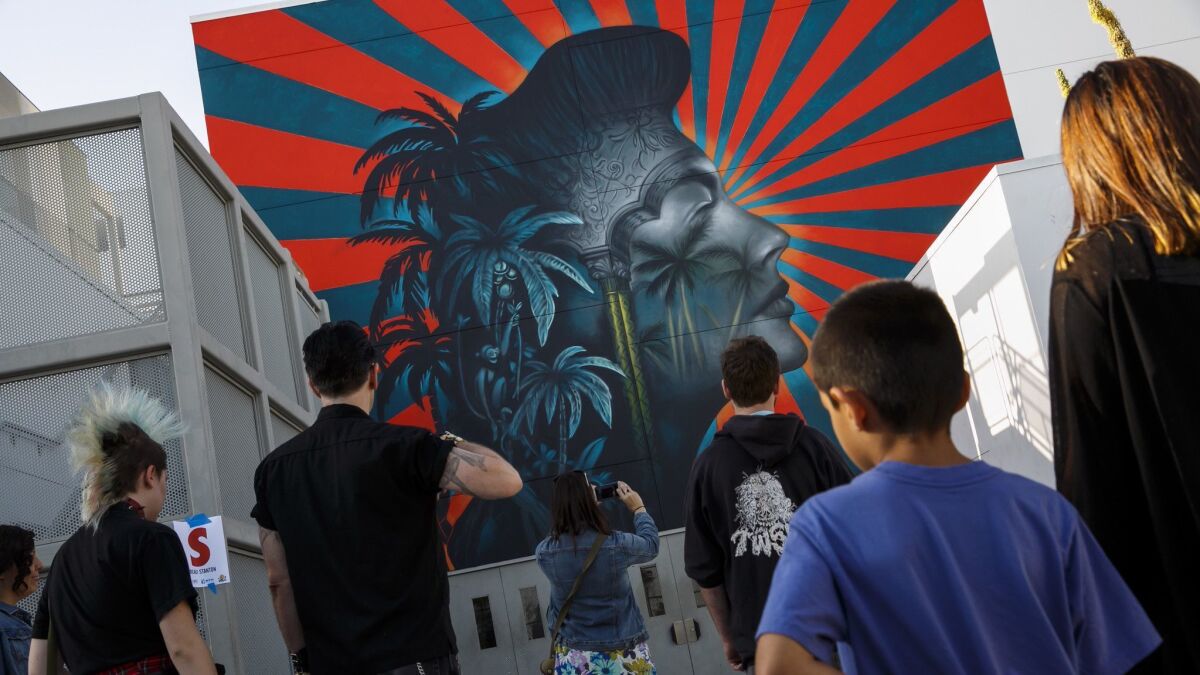Visitors look at the mural made by Beau Stanton in May 2016 at the Robert F. Kennedy Community Schools in Koreatown. Recently, the mural became a target of Korean activists.