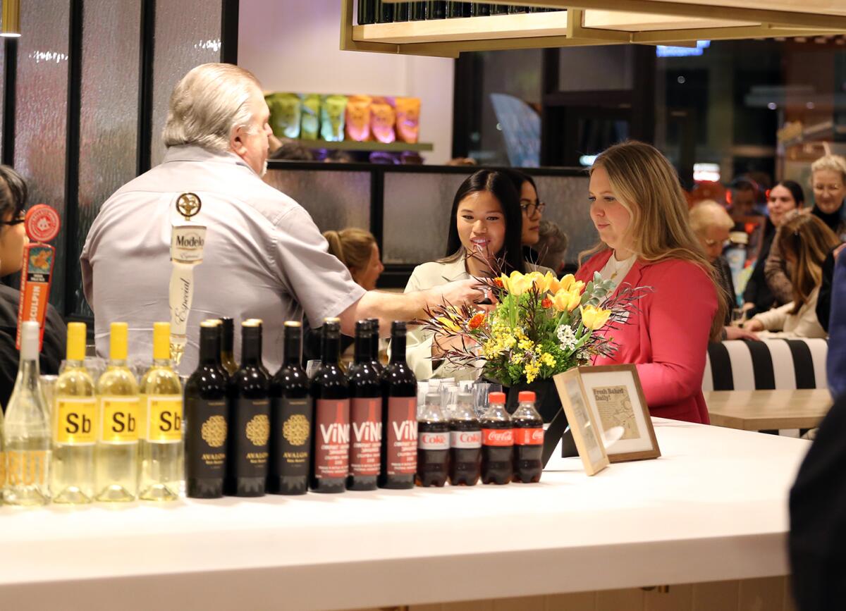 Guests have a drink at the new wine and beer bar during an event at Polly's Pies.
