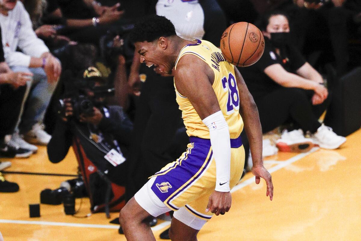 Lakers forward Rui Hachimura lets out a yell after dunking to end a fast break.