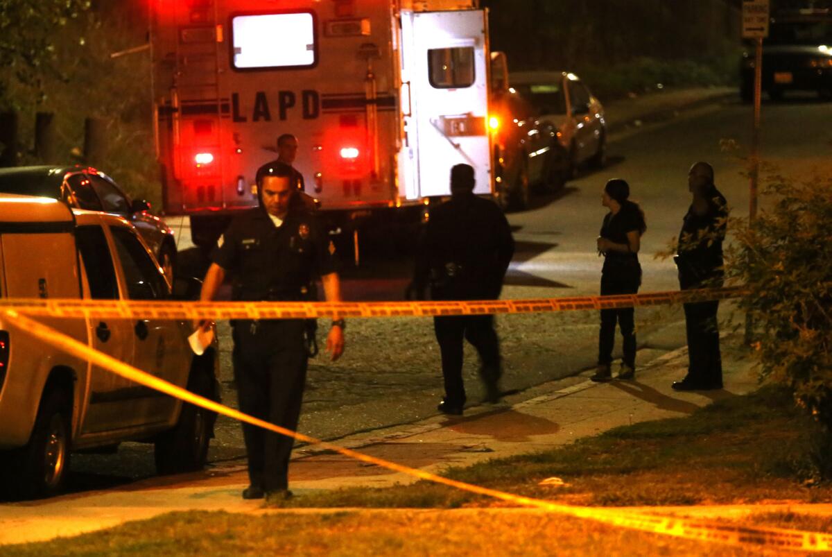 Police officers oversee the crime scene where the bodies of two women were discovered at the south edge of Ernest E. Debs Regional Park in Montecito Heights.