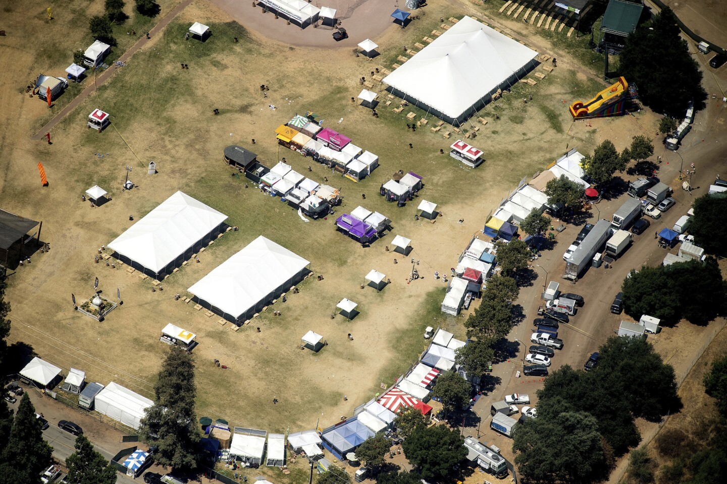 In this aerial photo, vendor booths line Christmas Hill Park, Monday, July 29, 2019, in Gilroy, Calif., the site of a shooting the day before at the Gilroy Garlic Festival. Authorities on Monday were searching for answers to why a 19-year-old opened fire on a popular food festival less than a mile from his parents' home in California, killing two children and another man, but believe many more people would have died if officers patrolling the event had not stopped the gunman so quickly.