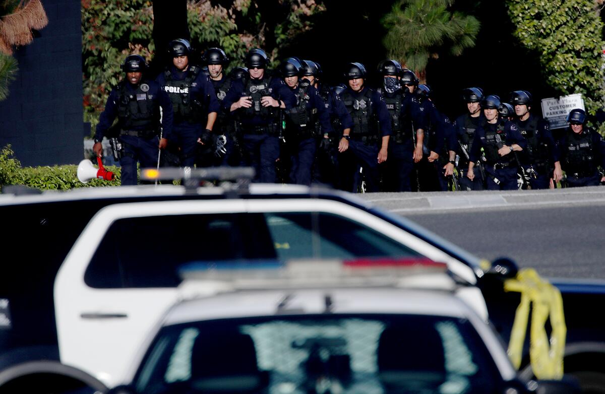  LAPD officers and Sheriff's deputies stage at the entrance to Peck Park