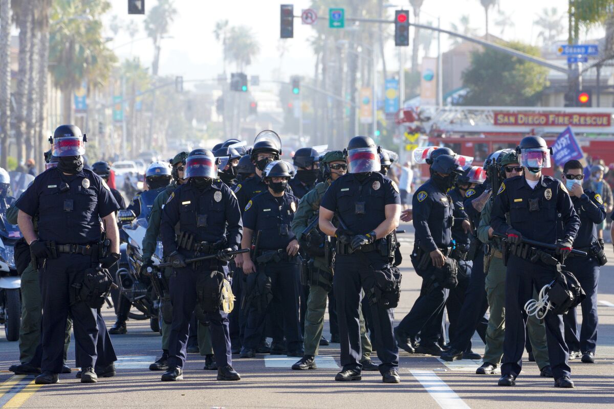 On Jan. 9, 2021, San Diego police officers line up on Mission Boulevard, mostly facing anti-Trump demonstrators