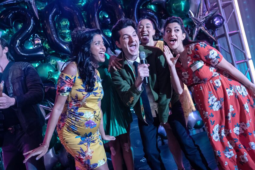 A group of friends sing onstage at a reunion.