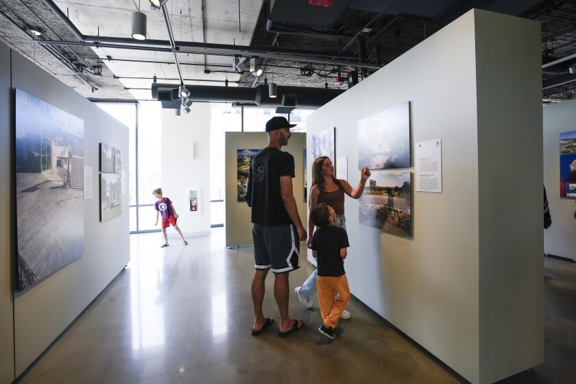 Bryan Daniels and his children enjoy one of the galleries in the second floor at UC San Diego Park & Market