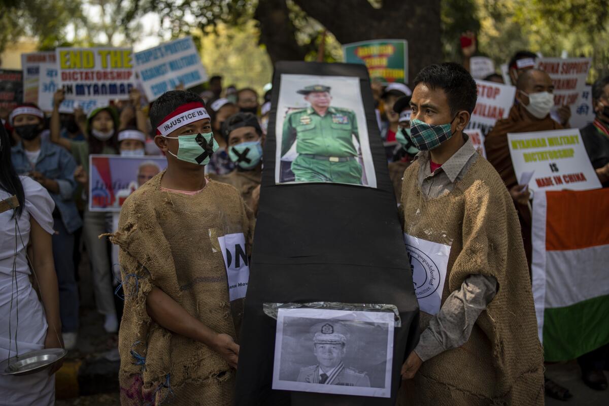 Chin refugees from Myanmar carry a mock coffins of Commander in chief, Senior Gen. Min Aung Hlaing during a protest against military coup in Myanmar, in New Delhi, India, Wednesday, March 3, 2021. (AP Photo/Altaf Qadri)