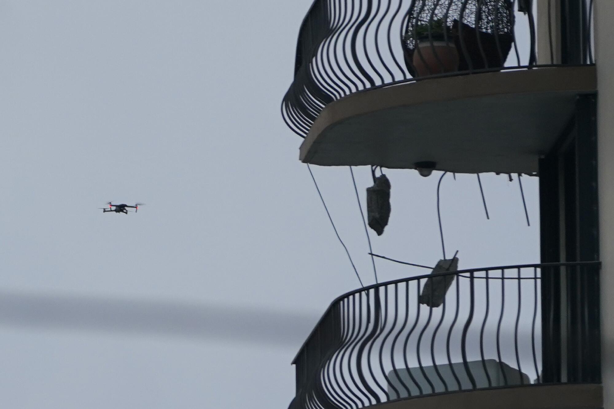 A drone flies near damaged balconies.