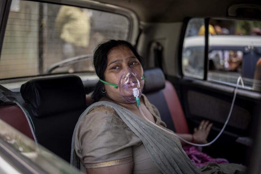 A COVID-19 patient sits inside a car and breathes with the help of oxygen provided by a Gurdwara, a Sikh house of worship, in New Delhi, India, Saturday, April 24, 2021. India’s medical oxygen shortage has become so dire that this gurdwara began offering free breathing sessions with shared tanks to COVID-19 patients waiting for a hospital bed. They arrive in their cars, on foot or in three-wheeled taxis, desperate for a mask and tube attached to the precious oxygen tanks outside the gurdwara in a neighborhood outside New Delhi. (AP Photo/Altaf Qadri)