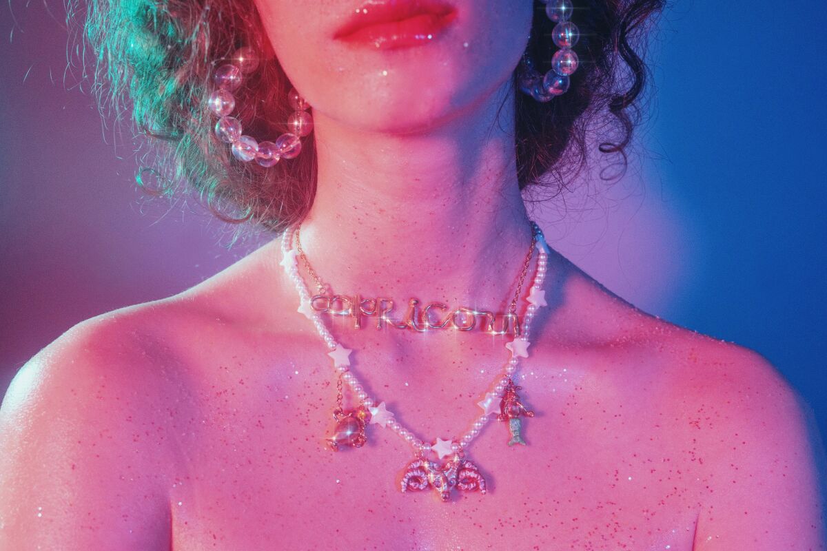 A woman's lips and neck with two necklaces draping on her chest