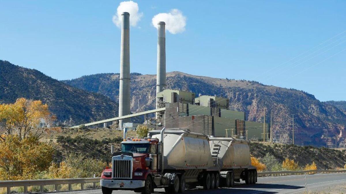 A coal truck drives by a coal-fired power plant near Huntington, Utah, in 2017.