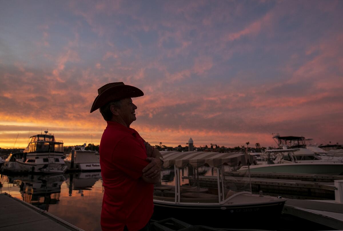 Greg Killingsworth watches as Rusty Richards, OC's singing cowboy, sings a song on his boat. Richards will be performing as part of Killingsworth's "A Campfire Cowboy Christmas" theme in his entry to this year's Newport Beach Christmas Boat Parade.