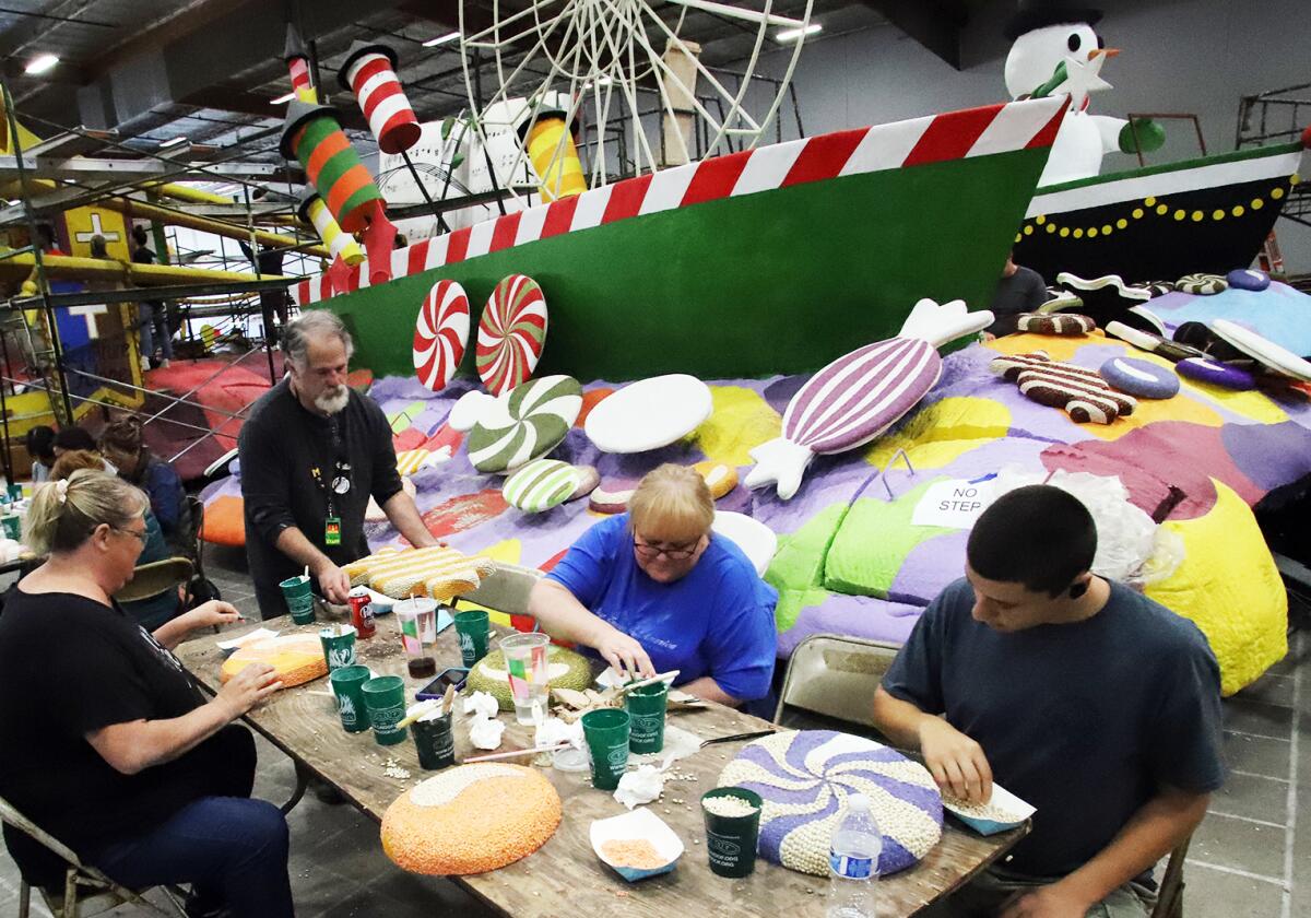 Volunteers work on Newport Beach's float for the Rose Parade at the Phoenix Decorating Co. in Irwindale on Saturday,