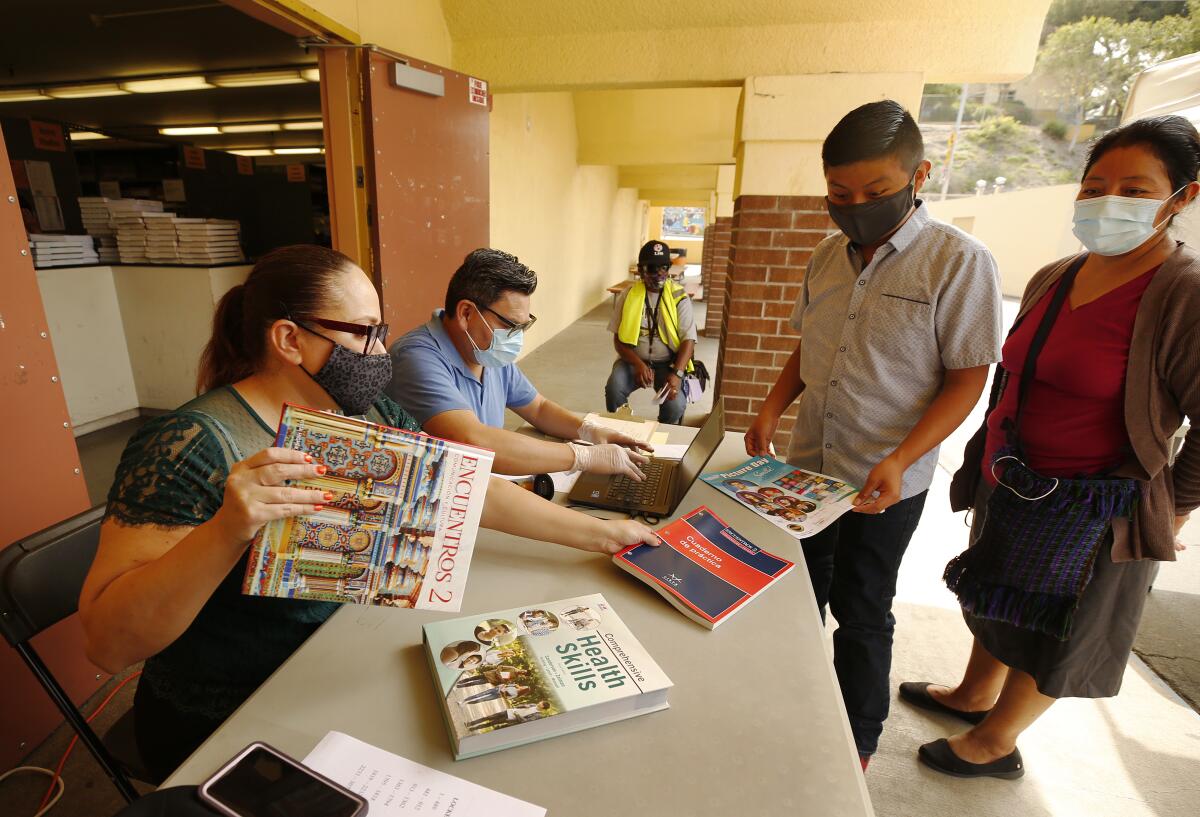 A student and his mother pick up school textbooks.