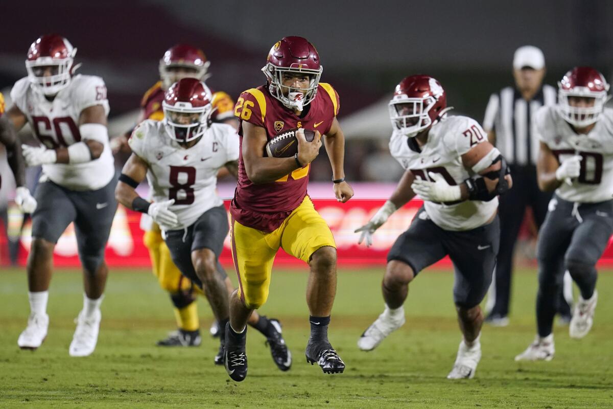 USC running back Travis Dye runs away from the Washington State defense