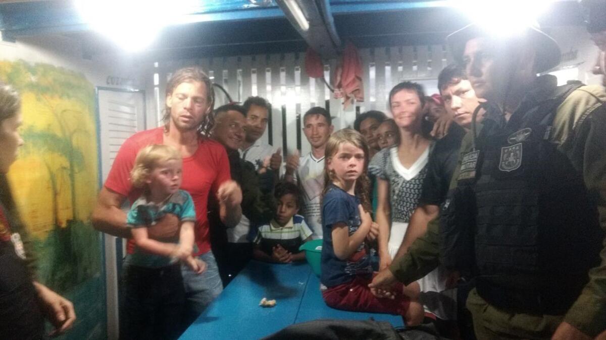This Nov. 1 photo provided by Brazilian officials shows Adam Harteau, left, Emily Harteau, third from right, and their two daughters with police and Brazilian villagers after the family's rescue.