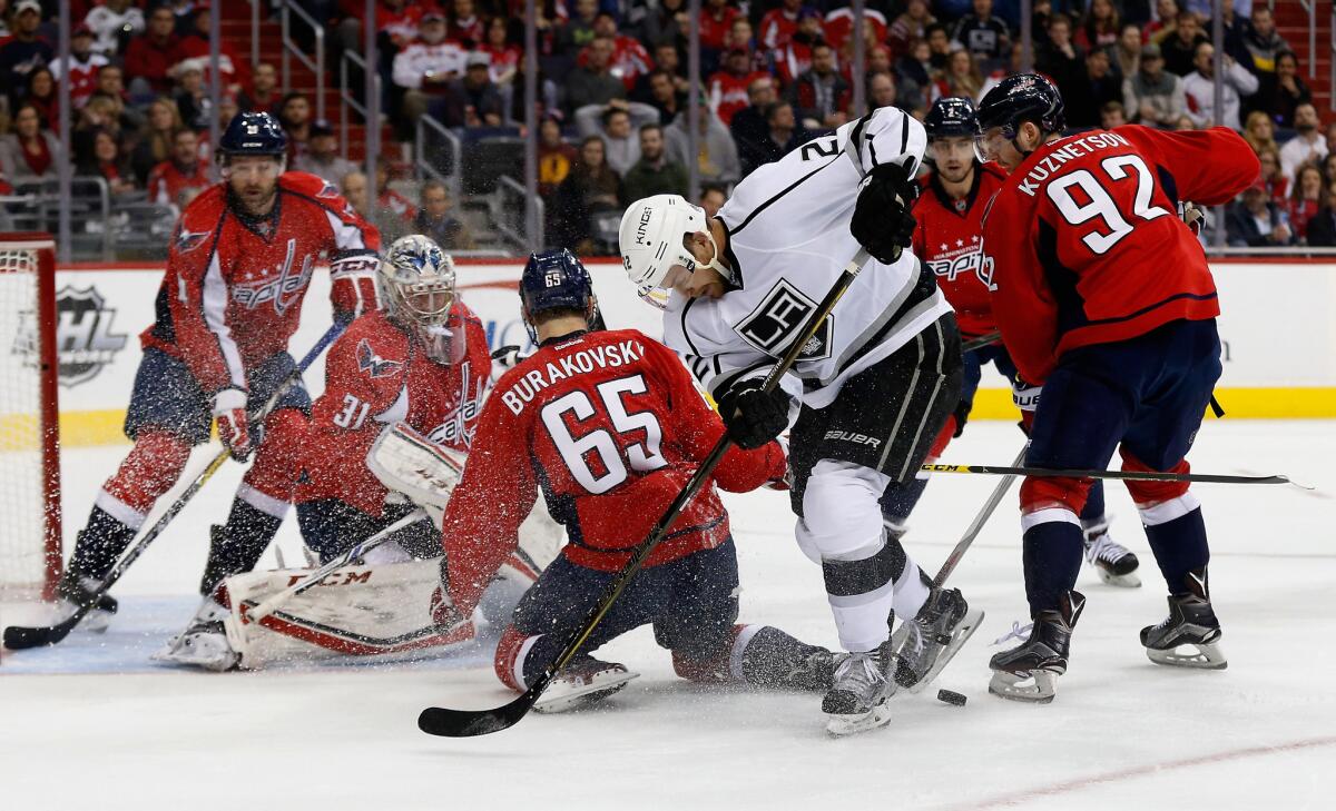 Kings' Trevor Lewis goes after the puck while surrounded by Washington Capitals players, including goalie Philipp Grubauer (31), Andre Burakovsky and Evgeny Kuznetsov.