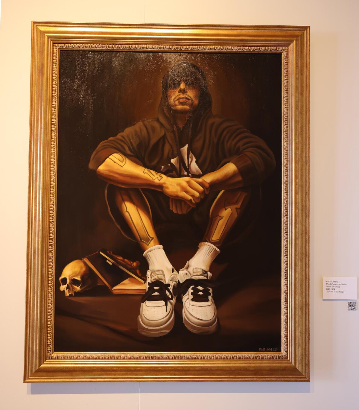 Artist Fabian Debora's painting "The Drifter in Meditation" shows a man in a hoodie sitting with his arms on his knees.