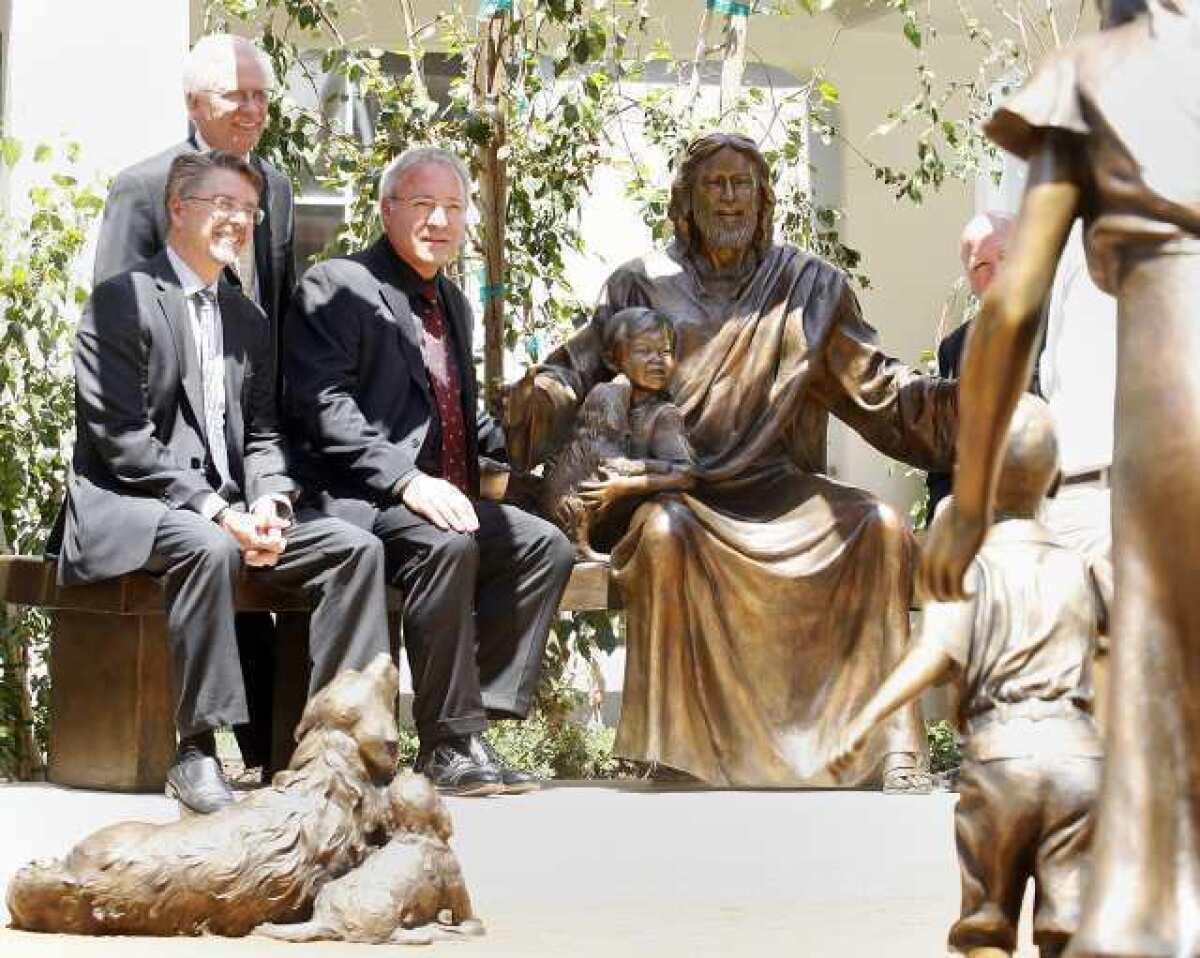 President and CEO Kevin Roberts, Bruce Nelson and sculptor Victor Issa pose with the sculpture that Issa created at Glendale Adventist Medical Center where the East and West towers meet for the dedication ceremony for the "Come Unto Me" sculpture.