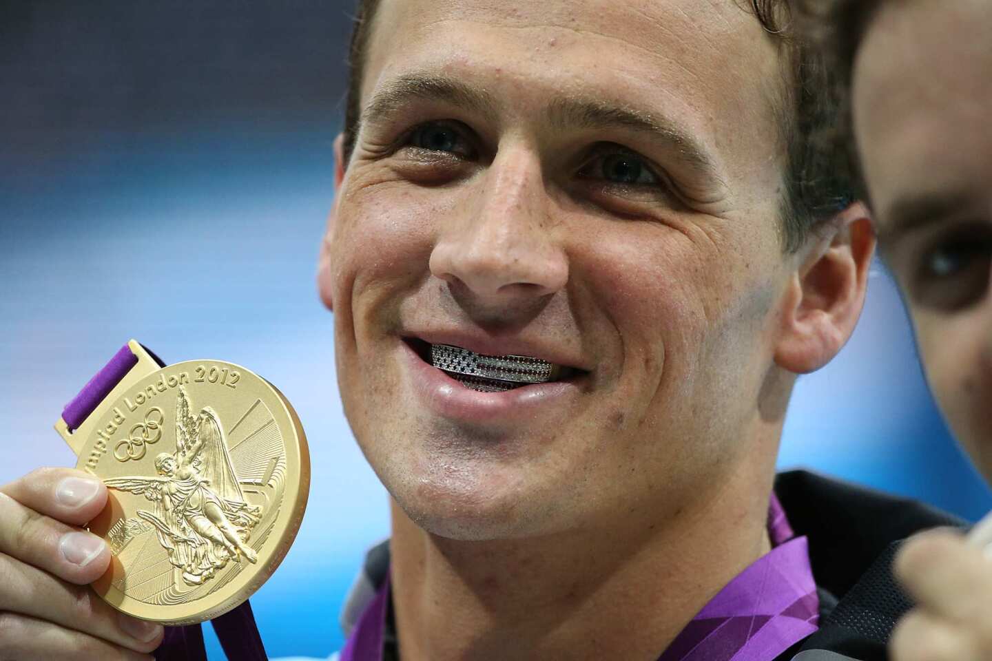 Ryan Lochte shows off his American flag grills and gold medal after winning the men's 400m individual medley.