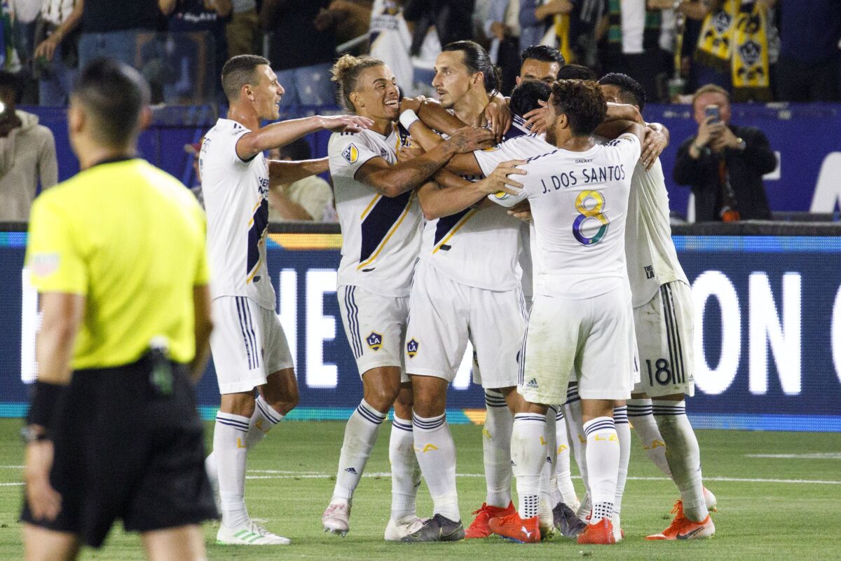 Zlatan Ibrahimovic, center, is swarmed by teammates after scoring one of his three goals against LAFC on Friday night.