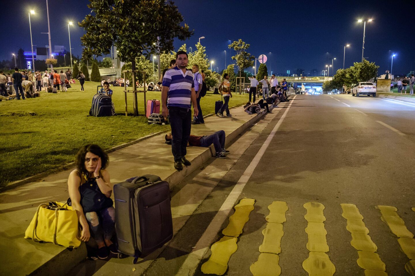 Travelers wait outside the airport after the deadly attack.