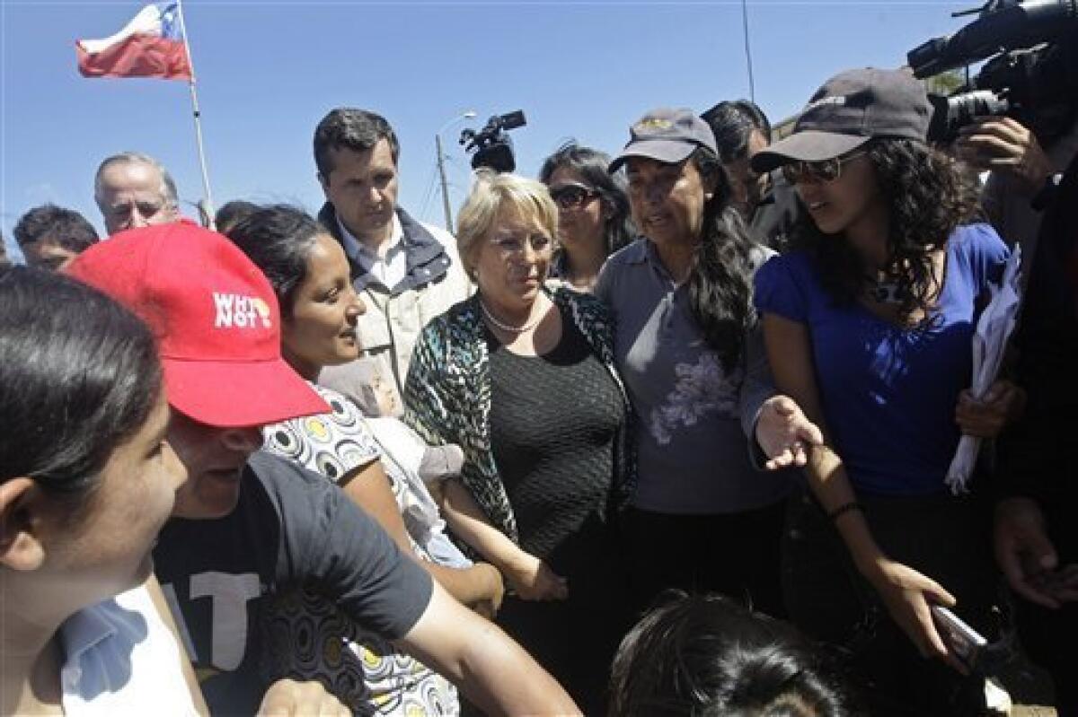 Chile's President Michelle Bachelet, center, arrives to Dichato, Chile, Monday, March 8, 2010. A devastating earthquake hit central Chile last Feb. 27, causing widespread damage. (AP Photo/Silvia Izquierdo)