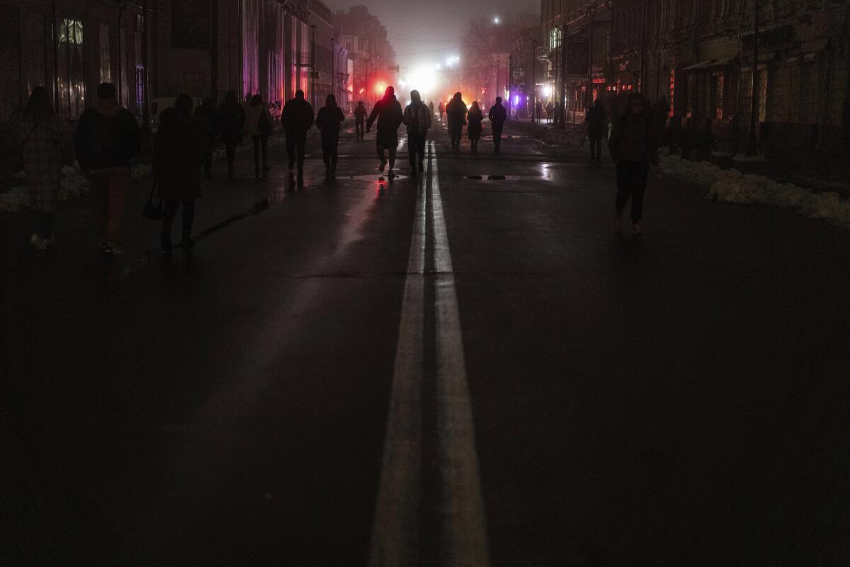 Silhouettes of people in Kyiv's city center amid a power outage