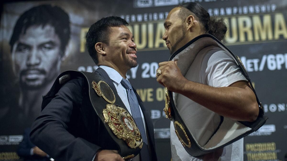 Manny Pacquiao, left, and Keith Thurman stand face to face during a news conference on Tuesday in New York. The two are scheduled to fight in a welterweight world championship boxing bout on July 20 in Las Vegas.