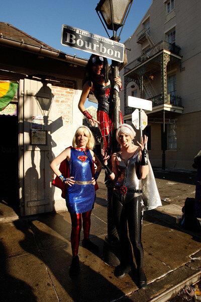 Women dressed as super heroes pose for a photo on Bourbon Street on Mardi Gras.