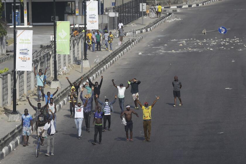 People demonstrate on the street to protest against police brutality in Lagos, Nigeria, Wednesday Oct. 21, 2020. After 13 days of protests against alleged police brutality, authorities have imposed a 24-hour curfew in Lagos, Nigeria's largest city, as moves are made to stop growing violence. ( AP Photo/Sunday Alamba)