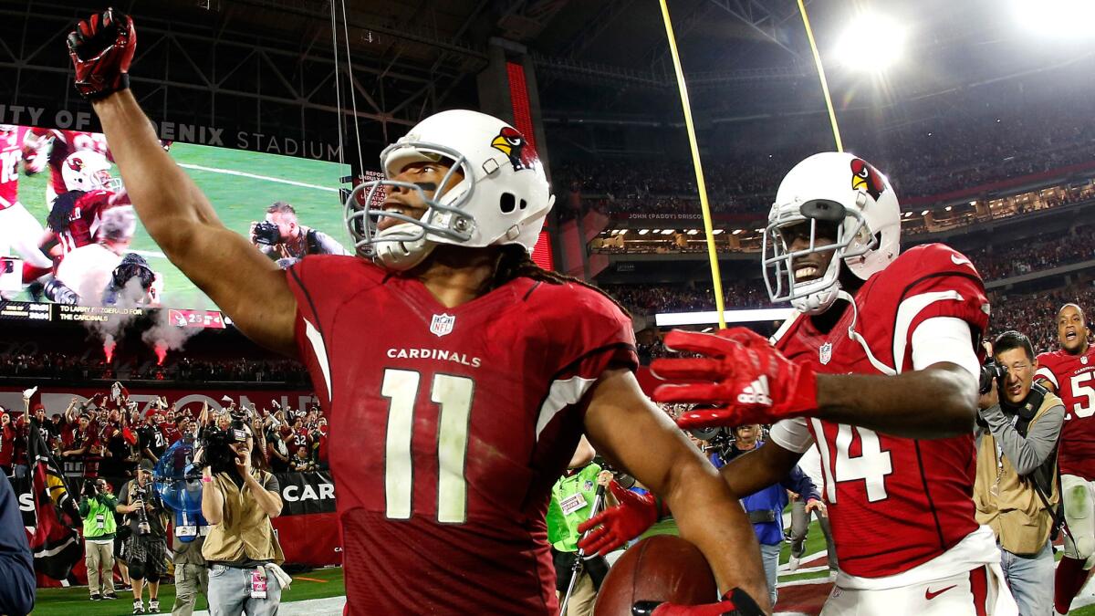 Cardinals wide receiver Larry Fitzgerald celebrates with teammate J.J. Nelson after scoring the game-winning touchdown against the Packers on Saturday night.