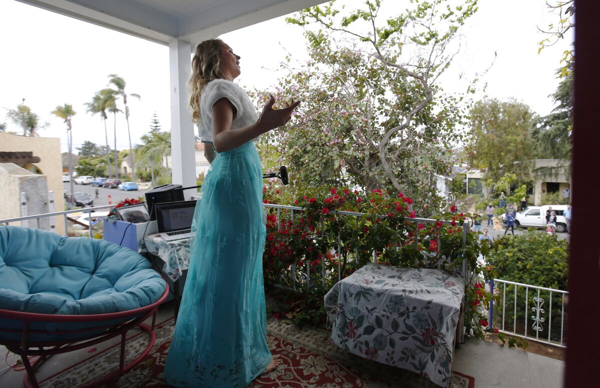Opera singer Victoria Robertson, a soprano, sings from the porch of her North Park home on April 19, 2020. 