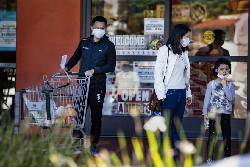 SAN GABRIEL, CA - JANUARY 29, 2020: Sarah Chong, middle, who is visiting from Shanghai, and her family wear masks in precaution of the coronavirus while shopping at San Gabriel Square on January 29, 2020 in San Gabriel, California. She and her family are visiting the U.S. for a month. (Gina Ferazzi/Los AngelesTimes)